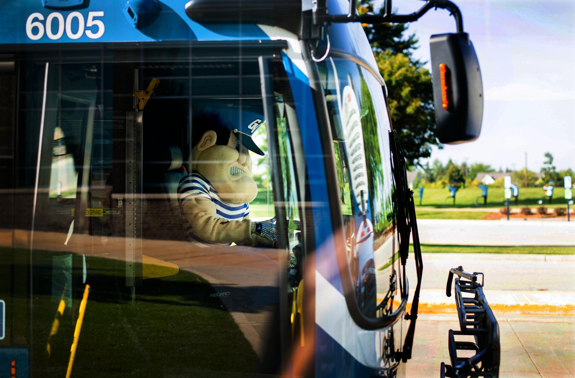 Louie the Laker driving a bus